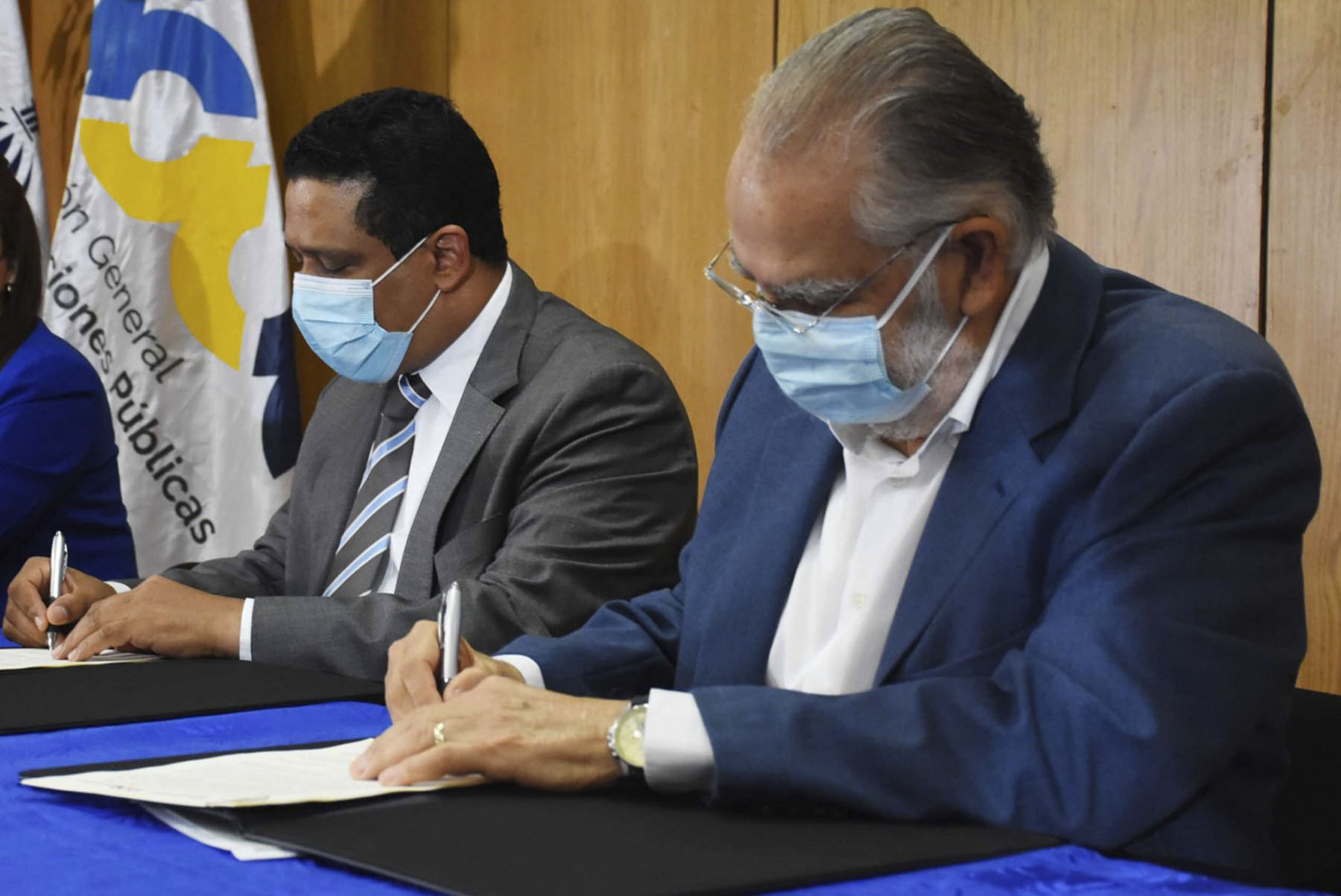 El ministro de Economía y presidente del Consejo del Centro de Fomento y Promoción de las ASFL, Miguel Ceara Hatton, y el director general de Contrataciones Públicas, Carlos Pimentel firman el acuerdo en un acto en la sede del ministerio de Economía, Planificación y Desarrollo.