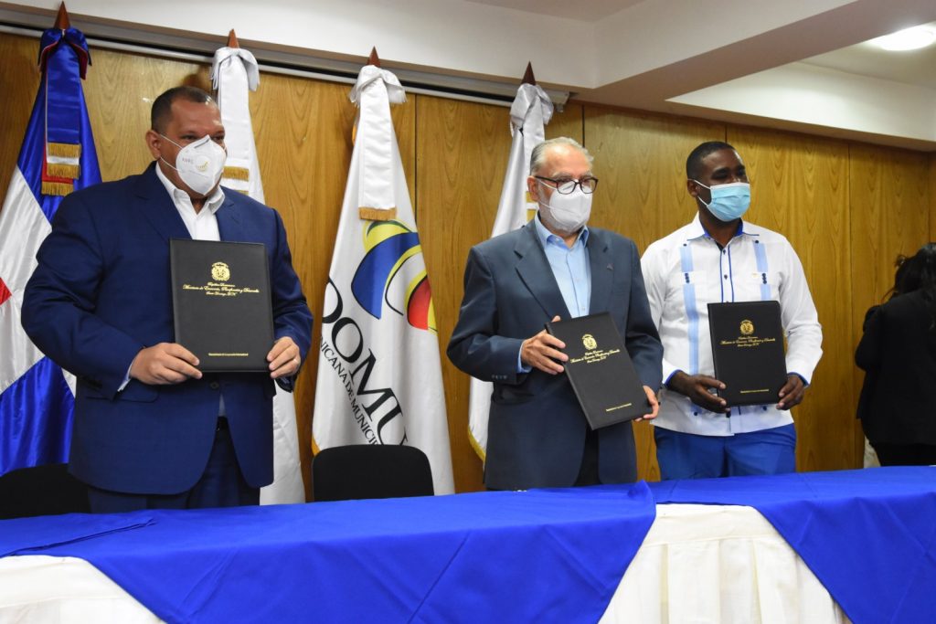 El ministro de Economía, Planificación y Desarrollo, Miguel Ceara Hatton, firma la carta compromiso con Carlos Guzmán, alcalde de Santo Domingo. 