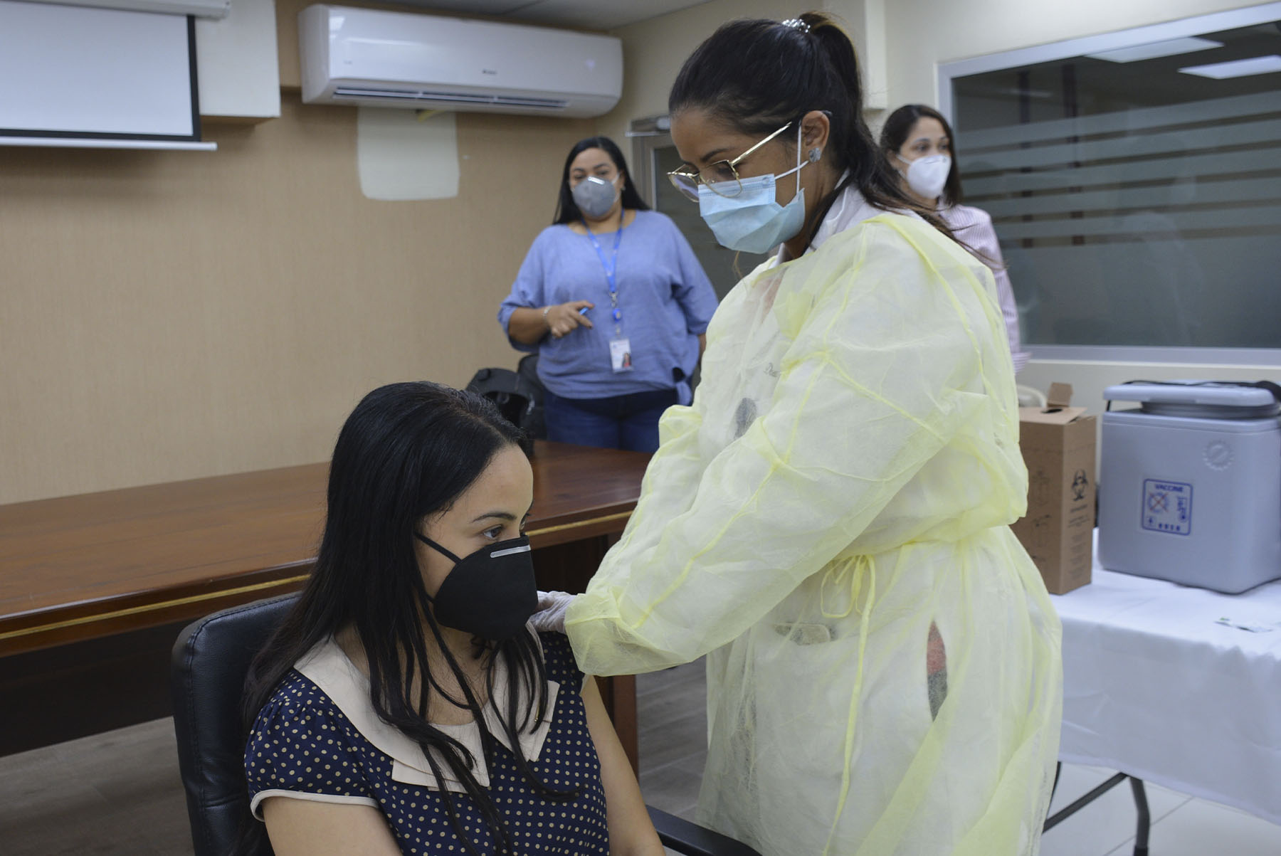 La doctora Kathia Peña, inocula a nuestra colaboradora Nathalie Gómez, técnica de la dirección de Compras del Ministerio de Economía, Planificación y Desarrollo.