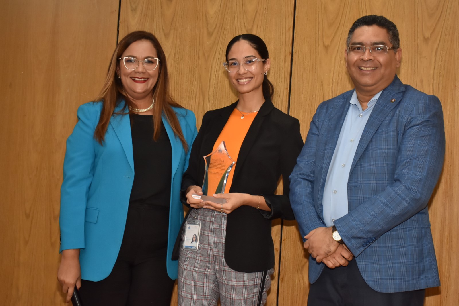 El Viceministro de Análisis Económico y Social, Alexis Cruz, hace entrega por su Desempeño Extraordinario a Rossel D. Mancebo de la Dirección de Análisis de Pobreza, Desigualdad y Cultura Democrática, le acompaña la directora de Recursos Humanos, Águeda Suarez.