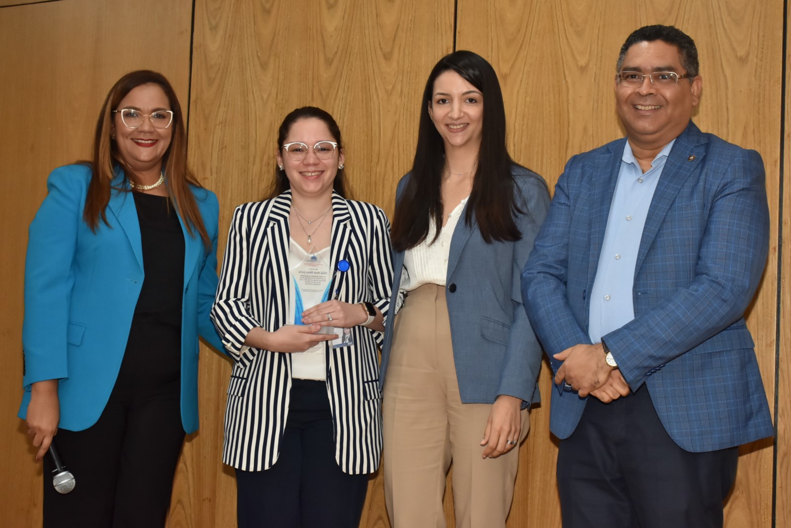 El Viceministro de Análisis Económico y Social, Alexis Cruz y Evalina Gómez, Especialista Sectorial de la Unidad Asesora de Análisis Económico y Social hacen entrega por su Desempeño Extraordinario a Yelidá María Blanco García de la Dirección de Análisis Económico Sectorial, le acompaña la directora de Recursos Humanos, Águeda Suarez.