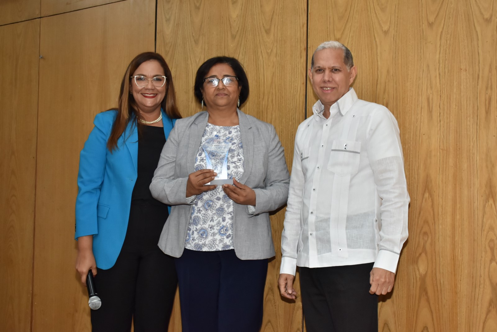 El viceministro de Ordenamiento Territorial y Desarrollo Regional, Domingo Matías y la directora de Recursos Humanos, Águeda Suarez, realizan entrega de reconocimiento por su Desempeño Extraordinario a Mercedes Feliciano, Directora de Gestión de Riesgo y Cambio Climático.