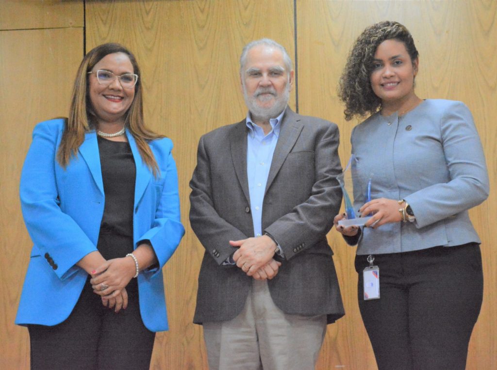 Miguel Ceara Hatton, ministro de Economía, Planificación y Desarrollo, realiza, entrega del reconocimiento al “Desempeño Extraordinario” a la directora de Tecnología de la Información Luz Feliz, le acompaña la directora de Recursos Humanos, Águeda Suárez. 