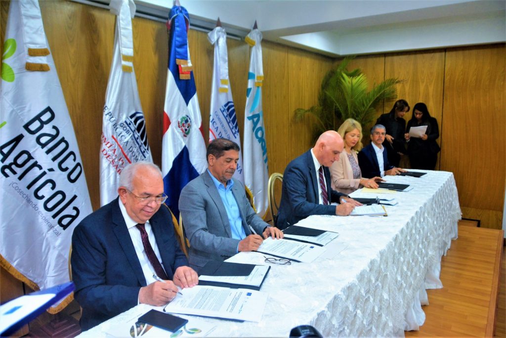 De izquierda a derecha, Fernando Durán, administrador general del Banco Agrícola; Limber Cruz López, ministro de Agricultura; Pável Isa Contreras, ministro de Economía, Planificación y Desarrollo; embajadora Katja Afheldt, jefa de la Delegación de la Unión Europea en República Dominicana y Guillermo Rondón, presidente ejecutivo del Banco Ademi, mientras realizan la firma de Anexo al Acuerdo Transferencia de la titularidad de la facilidad crediticia del programa "Medidas de Acompañamiento del Banano para República Dominicana (BAM)".