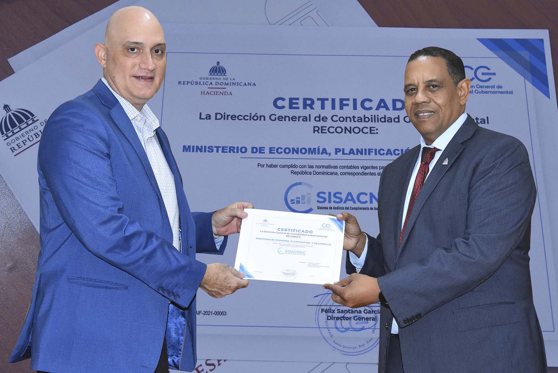 Pável Isa Contreras, ministro de Economía, Planificación y Desarrollo, recibe certificado de la DIGECOG de manos de Yamel Valera Castillo, viceministro Administrativo y Financiero del Ministerio de Economía.